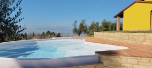 ein Pool im Hinterhof mit gelbem Haus in der Unterkunft Villa in campagna Costa al Bagno in Montopoli in Val dʼArno