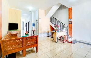 a living room with a staircase and a television at RedDoorz near Plaza Araya Malang in Blimbing