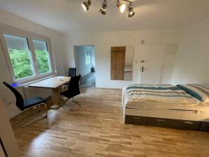 1 dormitorio con cama, escritorio y mesa en Wohnungen Bachhaus, en Traun