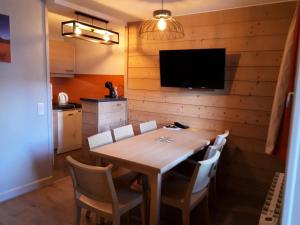 a dining room with a table with chairs and a television at Résidence Plagne Lauze - maeva Home - Appartement 3 pièces 7 personnes - S 954 in Mâcot La Plagne