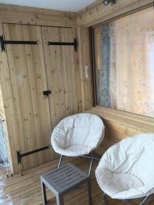two chairs and a stool in a room with wooden walls at Résidence Gentiannes - Appartements pour 5 Personnes 544 in Vars