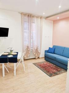 uma sala de estar com um sofá azul e uma mesa em La piccola bomboniera di Milano Nord em Milão