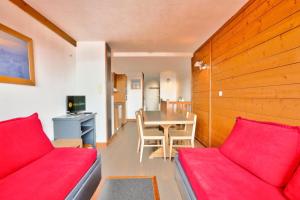 een woonkamer met een rode bank en een tafel bij Résidence L'Ours Blanc - maeva Home - Appartement 3 pièces 7 personnes - C 494 in Huez