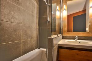 een badkamer met een wastafel, een bad en een douche bij Résidence L'Ours Blanc - maeva Home - Appartement 3 pièces 7 personnes - C 494 in Huez