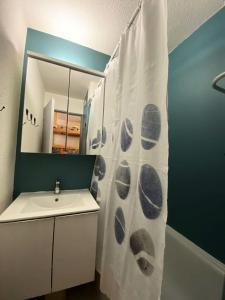 a bathroom with a sink and a shower curtain at Résidence Arc En Ciel C Porte C - Pièces 794 in Vénosc