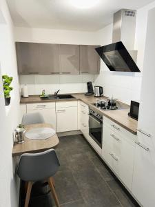 a kitchen with white cabinets and a table and a stove at MY HOME N 35 in Villingen-Schwenningen