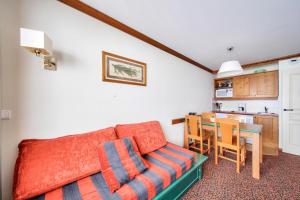 uma sala de estar com um sofá e uma mesa em Résidence La Marelle et Le Rami - maeva Home - Appartement 2 pièces 5 pers 644 em La Plagne Tarentaise