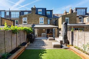 a backyard of a house with a patio at Veeve - By Richmond Lock in Isleworth