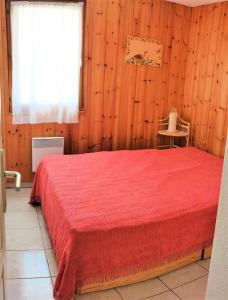 ein Schlafzimmer mit einem roten Bett und einem Fenster in der Unterkunft Résidence Mouflons - 3 Pièces pour 6 Personnes 994 in Vars