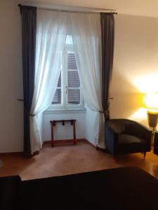 salon z oknem, krzesłem i lampką w obiekcie Interno 2 w Rzymie