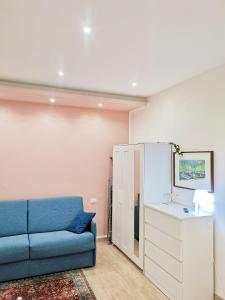 uma sala de estar com um sofá azul e um lavatório em La piccola bomboniera di Milano Nord em Milão