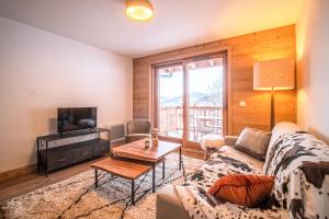 a living room with a couch and a tv at Résidence LUMI BATIMENT B - Appartement LUMI B pour 7 Personnes 224 in Valmorel