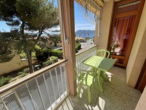 una mesa verde y una silla en un balcón con vistas en Vue mer, plage en face, tout à pied, en Saint-Elme
