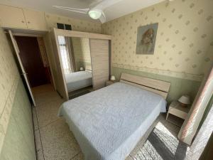 Dormitorio pequeño con cama y espejo en Vue mer, plage en face, tout à pied, en Saint-Elme