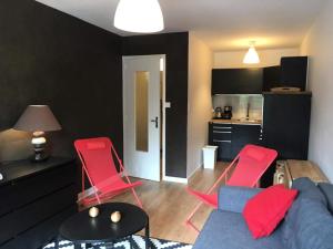 uma sala de estar com cadeiras vermelhas e um sofá azul em Résidence Cimes - 2 Pièces pour 6 Personnes 324 em Vénosc