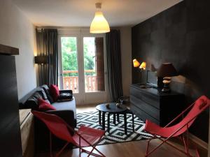 uma sala de estar com cadeiras vermelhas e um sofá em Résidence Cimes - 2 Pièces pour 6 Personnes 324 em Vénosc