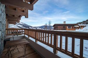 a wooden balcony with a bench and a house at Résidence LUMI BATIMENT B - Appartement LUMI B pour 5 Personnes 024 in Valmorel