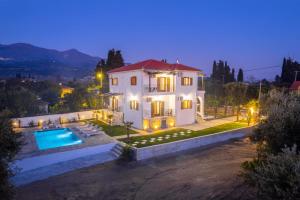 a house with a swimming pool at night at Kostis Orange Resort in Volos