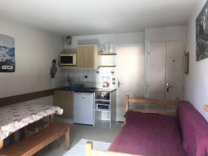 a small room with a kitchen and a bed at Résidence Andromede - Studio pour 4 Personnes 384 in Vénosc