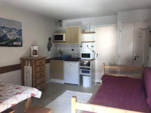 a small kitchen with a bed in a room at Résidence Andromede - Studio pour 4 Personnes 384 in Vénosc