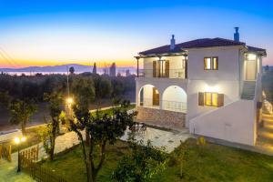a villa with a view of the city at sunset at Kostis Orange Resort in Volos
