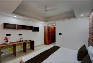 a bedroom with a bed and a desk and a ceiling at The Simran suites in Greater Noida