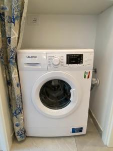 a white washing machine in a corner of a room at Luxury Blue Paradise Alassio in Alassio