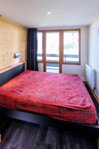 a bedroom with a large red bed in a room at Appartement rénové 3 Pièces 4-6 Personnes in La Plagne Tarentaise