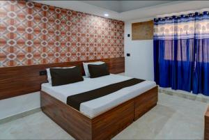a bedroom with a large bed with blue curtains at The Simran suites in Greater Noida