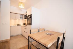 a kitchen and dining room with a wooden table at Résidence LUMI BATIMENT B - Appartement LUMI B pour 4 Personnes 994 in Valmorel