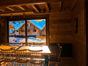 a dining room with a table and chairs and a window at Chalet Gaspard - Chalets pour 16 Personnes 494 in Vénosc
