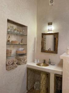 a bathroom with a sink and a mirror and towels at Villa Salvatore in Ghazoua