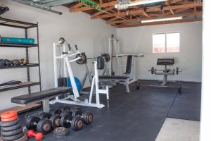 - une salle de sport avec des poids et des équipements dans l'établissement Central Villa Oasis, à Whangarei