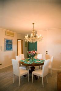 een eetkamer met een tafel met stoelen en een kroonluchter bij Blue Lake Home in Desenzano del Garda