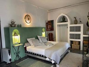 Un dormitorio con una cama con una pared verde y blanca en Villa Salvatore, en Ghazoua