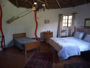 a bedroom with two beds and a tree in it at Gryffin Cottage at Hogwarts Forest in Hogsback