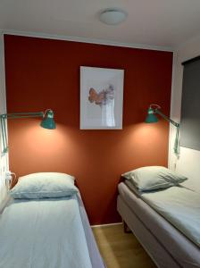 duas camas num quarto com uma parede vermelha em Drenths Landgoed, Lekker uit em Annerveenschekanaal