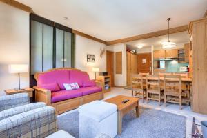a living room with a pink couch and a dining room at Résidence Les Arcs 1950 Le Village - maeva Home - Appartement 3 Pièces 6 Personnes - Sélection MAE-4534 in Bourg-Saint-Maurice