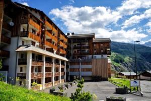 an apartment building with mountains in the background at Appartement confortable 2 Pièces Cabine 6 Personnes in Orcières