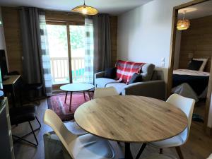 ein Wohnzimmer mit einem Tisch und einem Sofa in der Unterkunft Résidence LUMI BATIMENT B - Appartement LUMI B pour 4 Personnes 754 in Valmorel