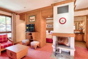 a living room with a fireplace and a bedroom at Résidence Les Arcs 1950 Le Village - maeva Home - Appartement 2 pièces 4 personnes - Prestige MAE-0134 in Bourg-Saint-Maurice