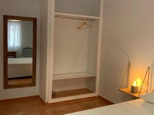 埃爾波索德洛斯弗萊爾斯的住宿－Cala Higuera，一间带镜子的卧室、一张床和一张床
