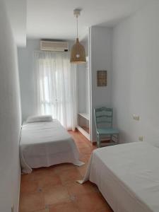 - une chambre avec 2 lits et une chaise dans l'établissement Cala Higuera, à El Pozo de los Frailes