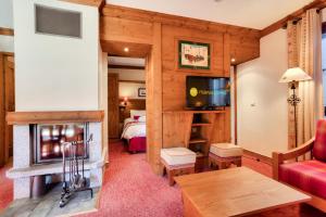 a living room with a fireplace and a bedroom at Résidence Les Arcs 1950 Le Village - maeva Home - Appartement 2 pièces 4 personnes - Prestige MAE-0204 in Bourg-Saint-Maurice