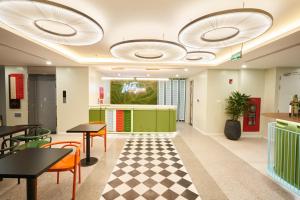 a lobby with tables and chairs and a checkered floor at Wilque Hotel Hanoi in Hanoi