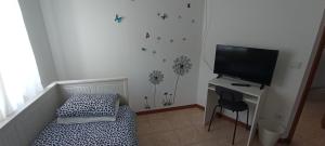 a bedroom with a bed and a flat screen tv at Casa das Tílias in Coimbra