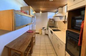 a small kitchen with a wooden table and a microwave at Résidence Schuss - Pièces 964 in Vars