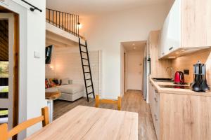 - une cuisine et un salon avec un escalier dans une petite maison dans l'établissement Les Résidences de Valmorel - maeva Home - Studio 4 personnes - Sélection 384, à Valmorel