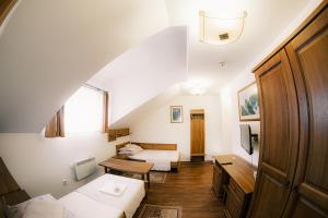 a attic room with two beds and a table at U GORAĽA in Lesnica