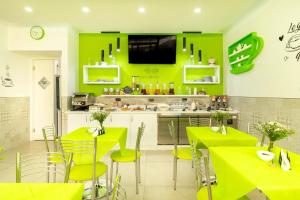 - une cuisine avec des murs vert clair, des tables et des chaises dans l'établissement Marini Hotel B&B, à Lido Marini